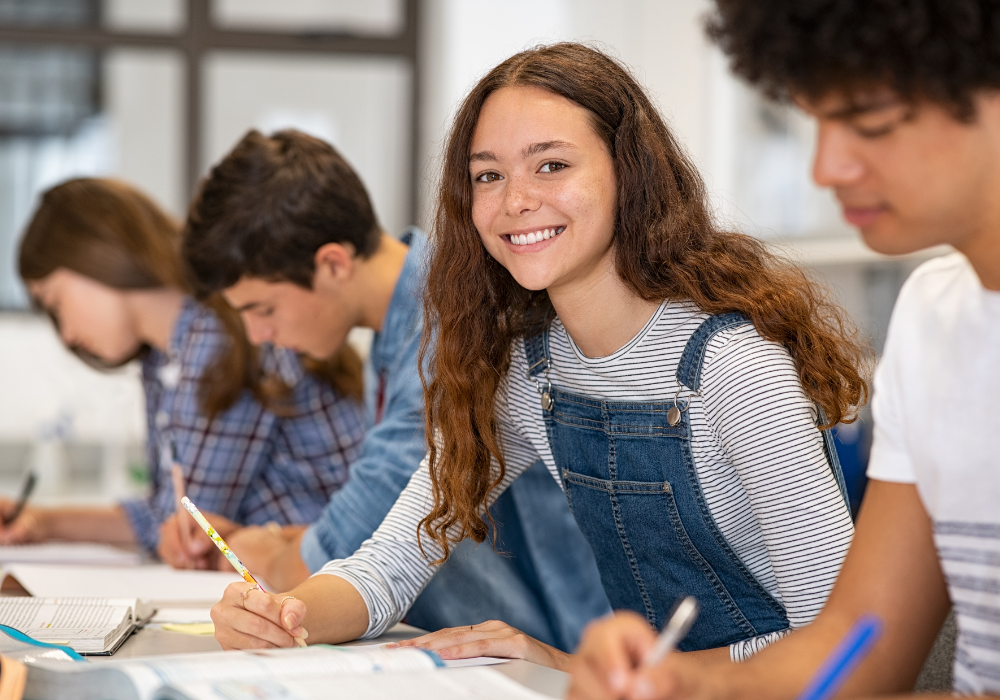 Elever i klasserom som arbeider med skoleoppgaver i videregående skole.